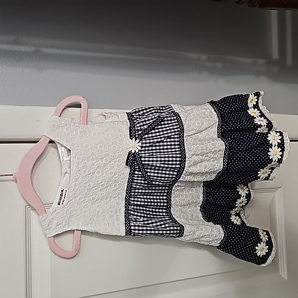24m sleeveless dress. The dress is white and navy blue with a flower trim.
